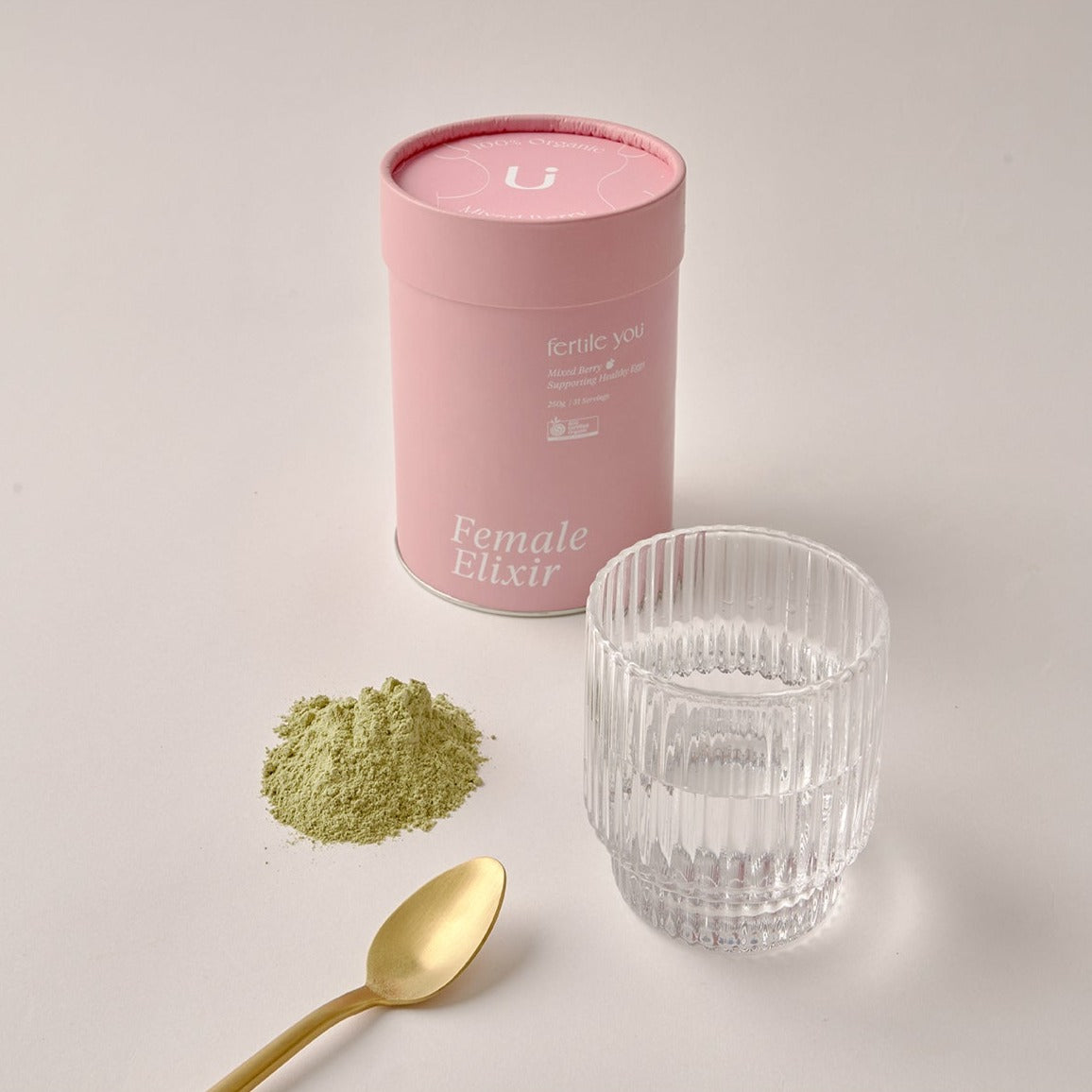 Mixed Berry Female Elixir with scoop and glass of water.